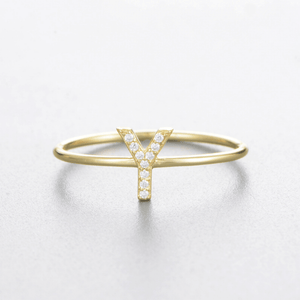 Gold ring with letter 'Y' design on a light gray background