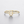 Gold bracelet with a letter 'S' design on a light gray background