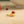 Gold ring with a red stone on a beige surface
