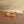 Gold ring with a white stone on a wooden surface