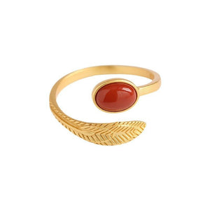 Gold ring with a red stone on a white background