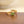 Gold ring with a green gemstone on a wooden surface