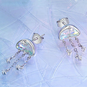 Heart-shaped earrings with star and chain details on a light blue textured background