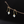 Flower-shaped earrings on a branch against a black background