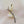 Gold and black leaf-shaped brooch with pearls on a beige background
