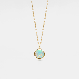 Gold necklace with a round opal locket on a light gray background