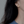 Gold dragonfly earring worn by a person with dark hair against a neutral background