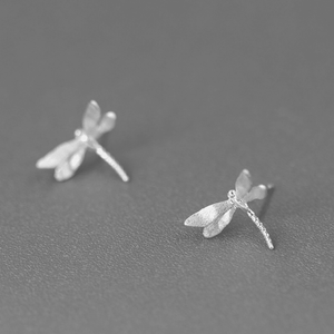Silver dragonfly earrings on a gray background