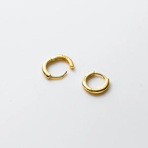 Pair of gold hoop earrings on a light gray background