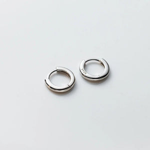 Pair of silver hoop earrings on a light gray background