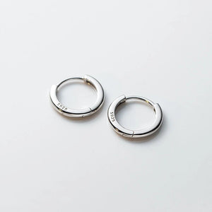 Pair of silver hoop earrings on a light gray background
