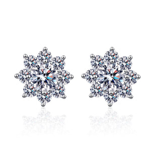 Snowflake-shaped earrings with clear gemstones on a white background