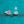 Two silver earrings on a teal glittery background