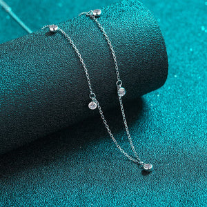 Silver necklace with heart-shaped charms on a teal background