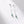 Silver earrings with green gemstones on a white background