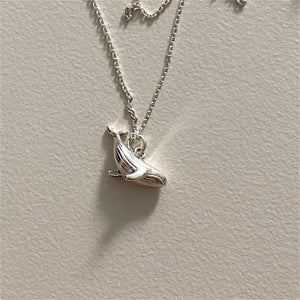 Two whale charm necklaces, one plated in silver and the other in gold, displayed against a neutral background.