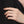 Hand wearing a silver ring with a black background