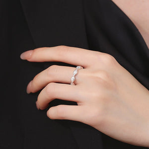 Hand wearing a silver ring with a black background