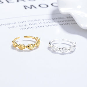 Gold and silver open rings on a white surface with text in the background