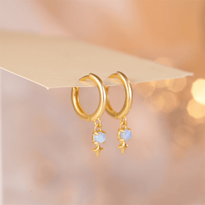 Gold hoop earrings with opalite stones on a soft background