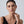 Woman wearing earrings with a plain background