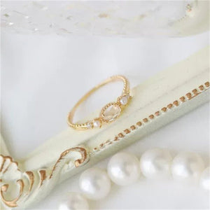 Gold bracelet and pearls on a marble surface