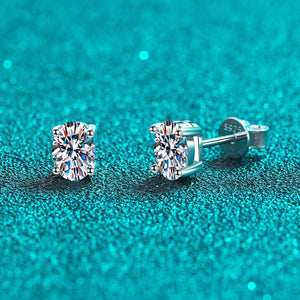 Silver stud earrings with gemstones on a teal glittery background