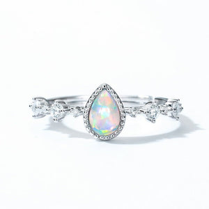 Silver ring with a teardrop-shaped opal stone on a white background