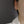 Gold hoop earring worn by a person against a dark background