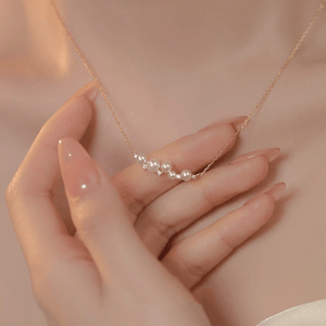 Pearl necklace being held by a hand against a soft background