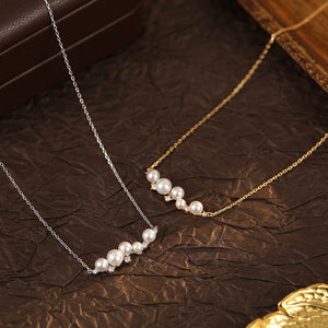 Two pearl necklaces on a textured brown surface