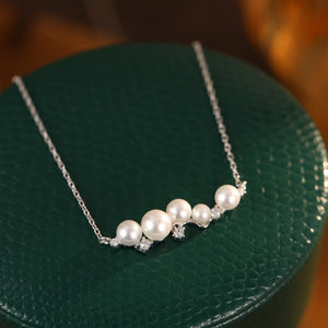 Pearl necklace on a green textured surface