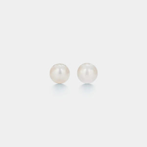 Pair of pearl earrings on a light gray background