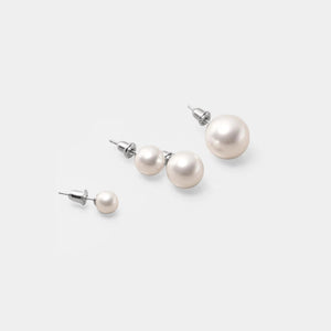 Set of pearl earrings on a light gray background