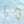 Two cat-shaped rings, one silver and one gold, on a light blue background.