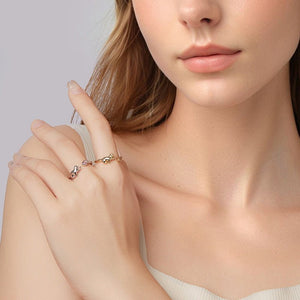 Close-up of a woman's hand wearing a delicate bracelet with a neutral background
