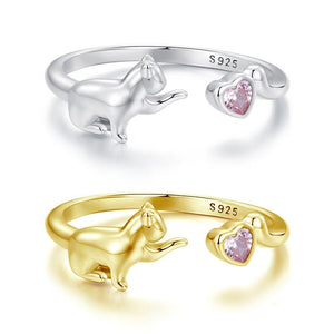 Two rings, one silver and one gold, with cat-shaped designs and pink gemstones on a white background.