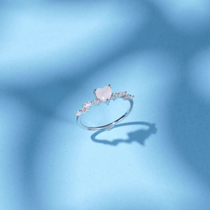 Delicate ring with a heart-shaped pink gemstone on a blue background