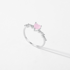 Silver ring with a pink gemstone on a light gray background