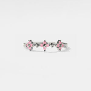 Silver ring with pink gemstones on a white background