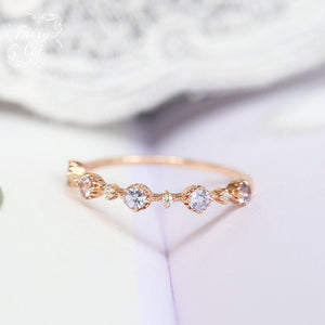 Gold ring with embedded stones on a soft white background