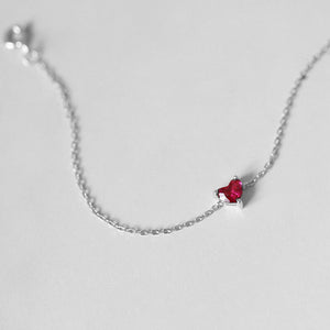 A gold-plated bracelet made of 925 sterling silver, featuring a red heart-shaped charm on a chain.