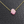 Pink glittery Hamsa hand necklace on a gold chain against a dark textured background