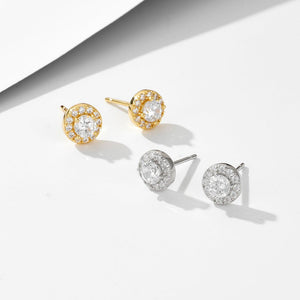 Gold and silver earrings with clear gemstones on a white background