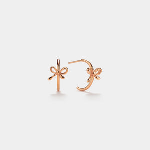 Rose gold bow-shaped earrings on a light gray background