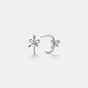 Silver bow-shaped earrings on a light gray background