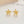 Gold flower-shaped earrings on a light background