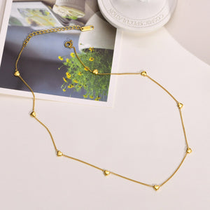 Gold anklet on a light surface with a blurred background