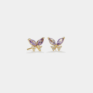 Butterfly-shaped earrings with purple gemstones on a white background