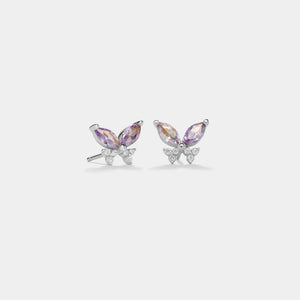 Butterfly-shaped earrings with purple gemstones on a white background